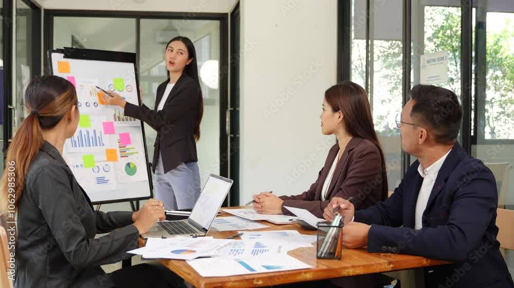 Asian Business Group Chat about graph work Present in meetings, in the office Asian Business Group Chat about graph work Present in meetings, in the office