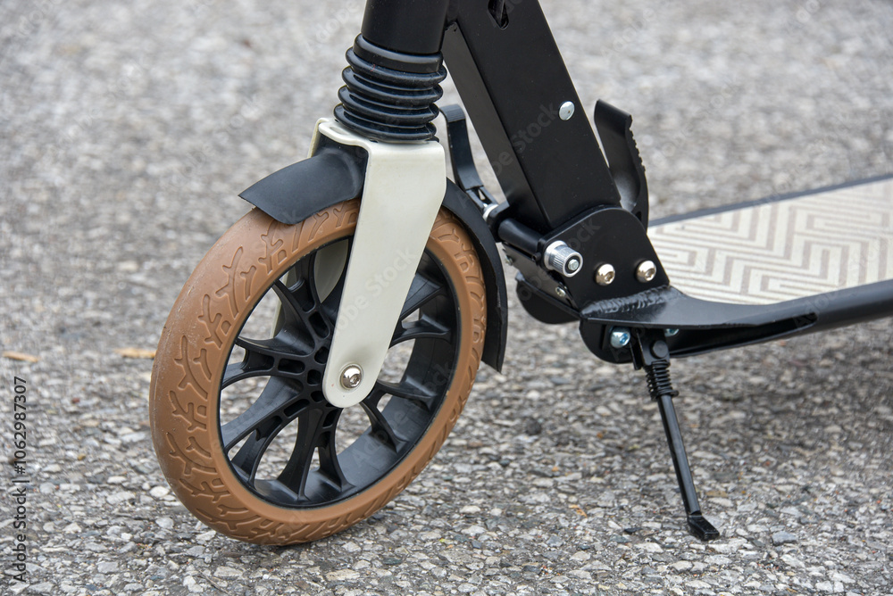 Front wheel of a scooter on asphalt. Close-up. Front wheel of a scooter on asphalt. Close-up.