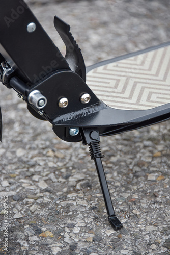 The scooter's footrest is on the asphalt.