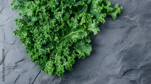 Curly Kale. Fresh raw Curly Kale leaves on gray stone background, top view. Ready for delicious healthy salad, vegan food, superfood.