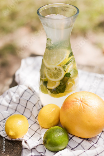 Glass bottle of lemonade with lemons kept on napkin