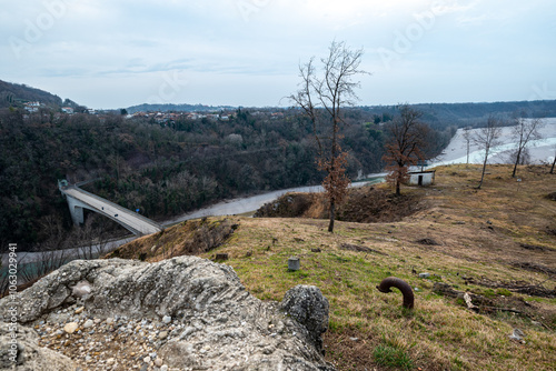 The bridge over Tagliamento river at Pinzano in Friuli, a big rock and a bent metal pipe with a little white house in the center photo