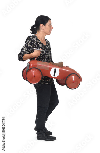 side view of a walking woman carring toy car on white background