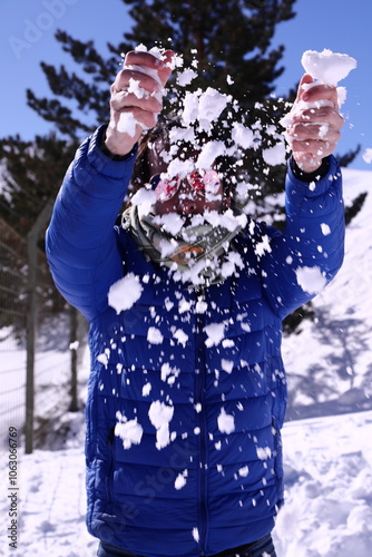 Person playing with snow on a sunny winter day