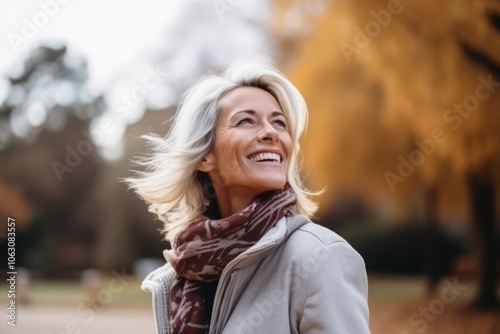 Portrait of a happy senior woman smiling in the autumn park.