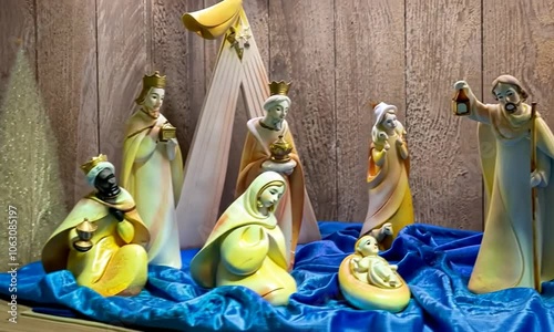 Crèche roumaine jaune et bleue avec santons anciens et traditionnels, décor de Noël artisanal sur fond en bois. photo