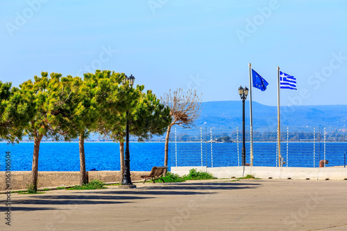 Pylos, Peloponnese, Greece, greek and EU flags, trees and sea view. Greek vacation background photo