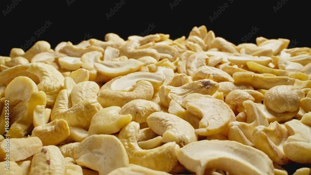Cashews pile. Group of peeled cashews. Camera slide with macro lens. Healthy vegan food concept. Harvest of nutrient rich snack. Close-up in 4K, UHD Cashews pile. Group of peeled cashews. Camera slide with macro lens. Healthy vegan food concept. Harvest of nutrient rich snack. Close-up in 4K, UHD