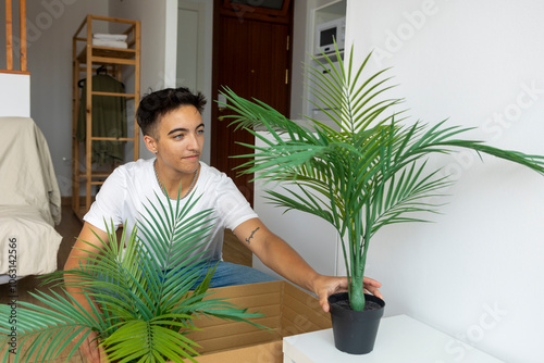 Trans man organizing new home with plants