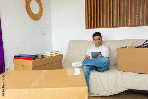 Trans man relaxed in new home among moving boxes photo