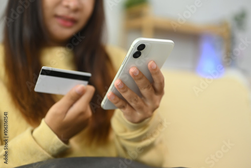 Cropped shot young woman shopping online with smartphone and credit card