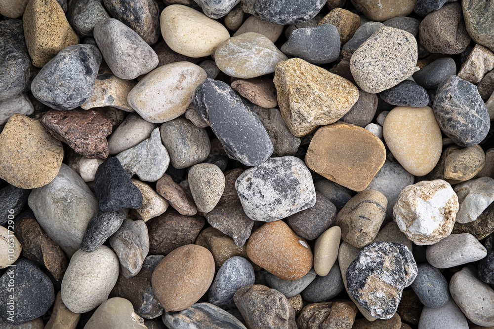 smooth colorful river stones with rounded shapes in earthy tones covering the surface of the ground
smooth colorful river stones with rounded shapes in earthy tones covering the surface of the ground