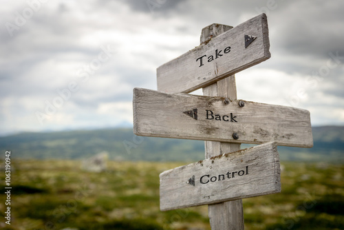 take back control text quote written on wooden signpost oudoors in mountain scenery. photo