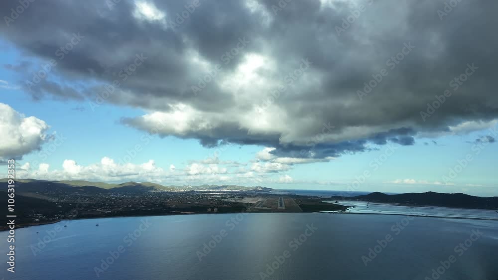Pilot’s perspective POV FPV approaching to Ibiza’s airport as seen by the pilots of a jet from the cockpit overflying the Mediterranean Sea and flying under a layer of grey clouds, runway ahead. 4K Pilot’s perspective POV FPV approaching to Ibiza’s airport as seen by the pilots of a jet from the cockpit overflying the Mediterranean Sea and flying under a layer of grey clouds, runway ahead. 4K