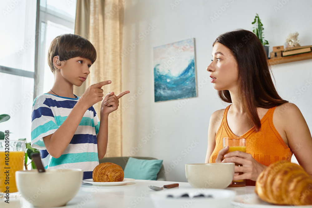 A young boy engages with his mother at the breakfast table, sharing a heartfelt conversation. A young boy engages with his mother at the breakfast table, sharing a heartfelt conversation.