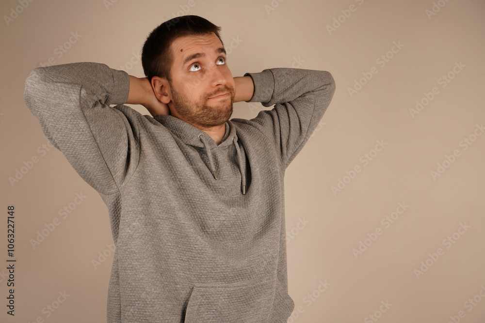 Young guy standing in front of camera with neutral background. Person looking at camera having crossed hands. Handsome man. Man in casual clothes with side view. Young guy standing in front of camera with neutral background. Person looking at camera having crossed hands. Handsome man. Man in casual clothes with side view.