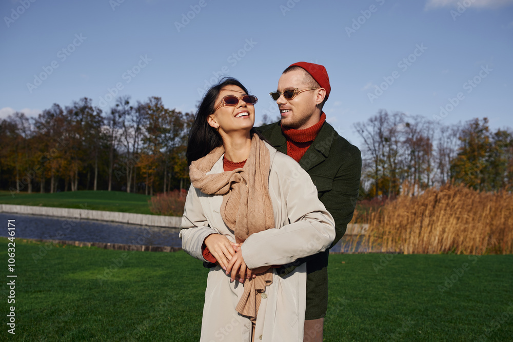 A warm hearted couple enjoys each others company in vibrant autumn attire under a clear sky. A warm hearted couple enjoys each others company in vibrant autumn attire under a clear sky.
