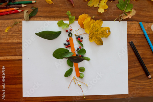 Sweet child, boy, applying leaves using glue while doing arts and crafts at home