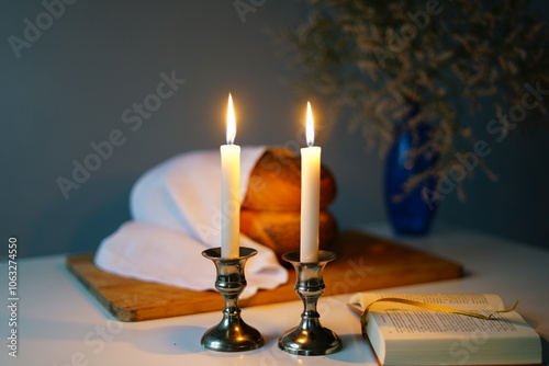 Shabbat or Sabbath kiddush ceremony composition with a traditional sweet fresh loaf of challah bread, glass of red kosher wine and candles on a vintage wood table with copy space