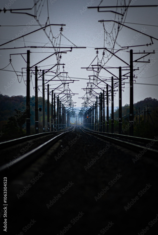 Railway road at autumn evening with autumn colors.Railroad near the forest with powerlines over the trees.Clouds in the sky,photography in the rainy weather .Landscape photo with train on the rails Railway road at autumn evening with autumn colors.Railroad near the forest with powerlines over the trees.Clouds in the sky,photography in the rainy weather .Landscape photo with train on the rails