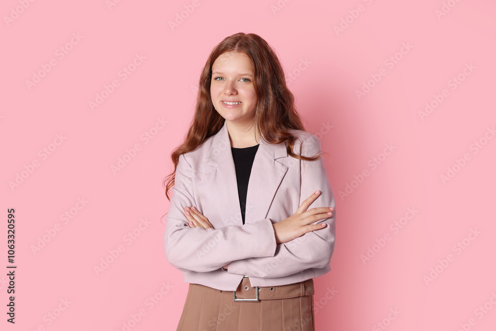 Smiling teenage girl with crossed arms on pink background Smiling teenage girl with crossed arms on pink background