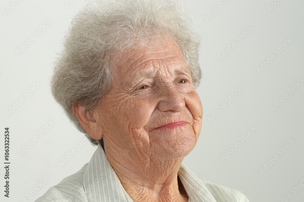 Portrait of senior woman on light grey background, closeup Portrait of senior woman on light grey background, closeup