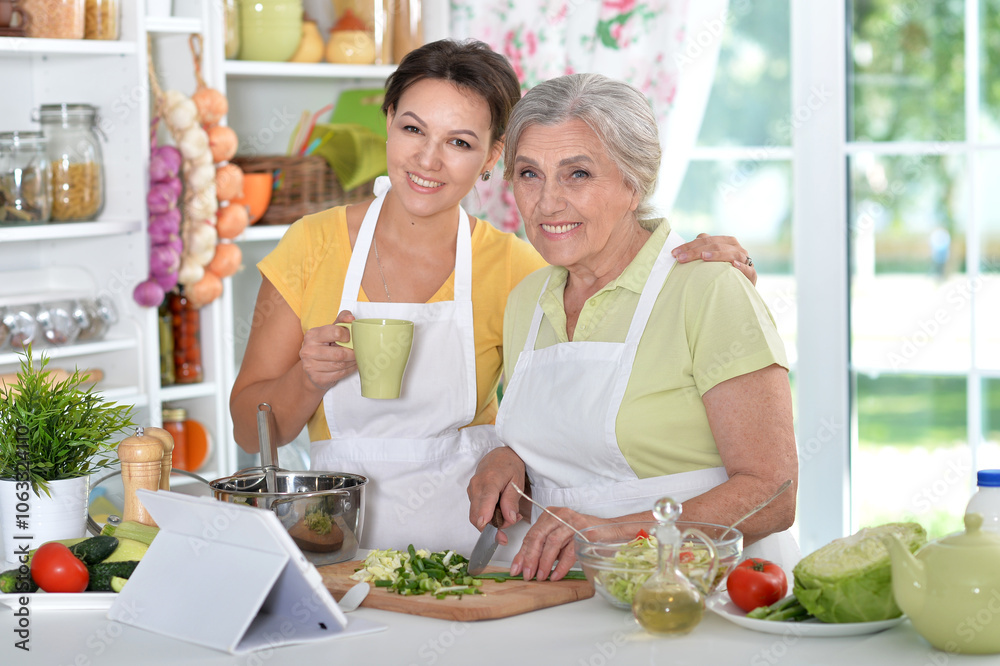Elderly woman with her daughter cooking in the kitchen Elderly woman with her daughter cooking in the kitchen