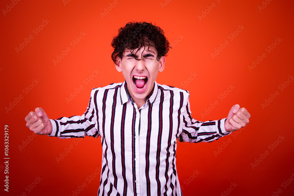 A funny young attractive guy with a curly hairstyle poses in the studio. A funny young attractive guy with a curly hairstyle poses in the studio.