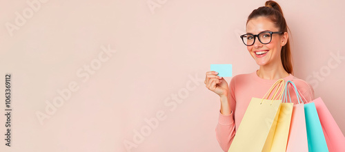 The woman holds a stack of colorful shopping bags in one hand and an empty credit card in the other. A banner with a woman and shopping, which suggests shopping. The situation is neutral. photo