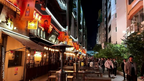 Bustling Shibuya alleyway at night with lantern-lit izakayas and lively crowds under city lights