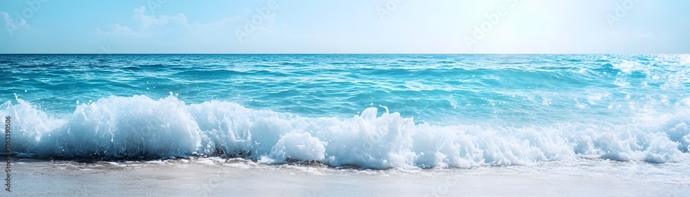 Fototapeta premium A Gentle Wave Crashing on a Sandy Beach Under a Clear Blue Sky