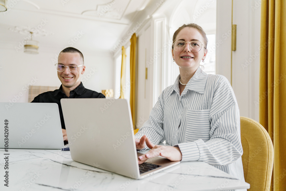 Two Professionals Working Collaboratively at a Bright and Modern Office Space With Large Windows and Yellow Curtains Two Professionals Working Collaboratively at a Bright and Modern Office Space With Large Windows and Yellow Curtains