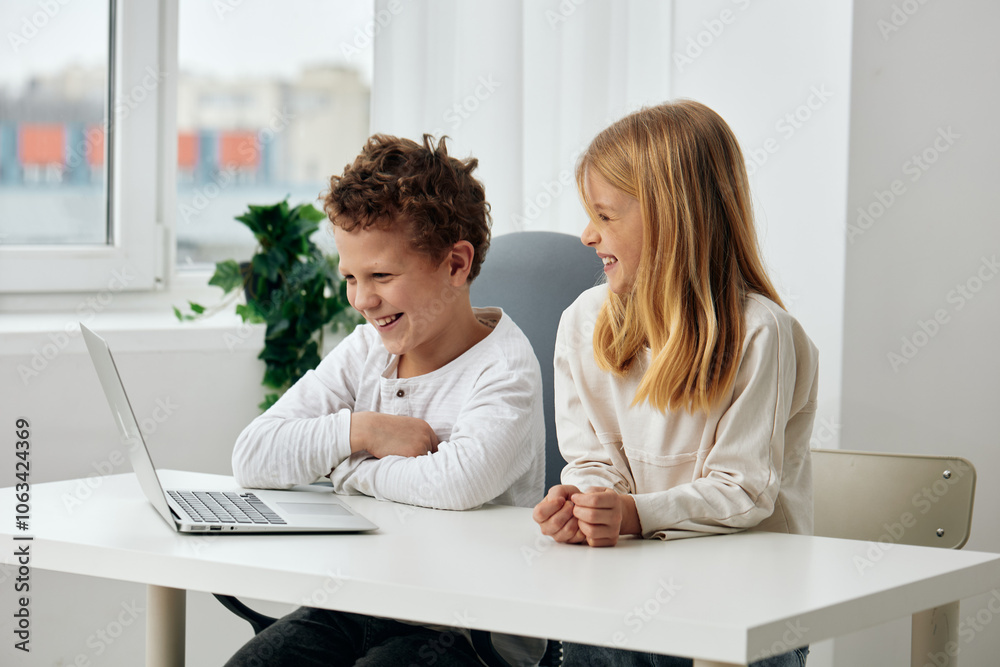 Happy Caucasian boy and girl sitting at a table in their cozy living room, fully absorbed in their elearning session on laptops Engrossed in their studies, the siblings are wearing headphones, Happy Caucasian boy and girl sitting at a table in their cozy living room, fully absorbed in their elearning session on laptops Engrossed in their studies, the siblings are wearing headphones,
