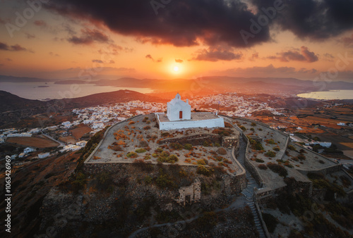 Obraz na płótnie Stunning view from Milos Island's peak, Greece: a white church overlooks the vast Aegean Sea, surrounded by rolling hills and the iconic Cycladic landscape. w salonie
