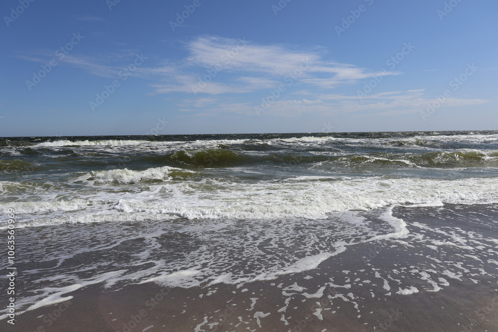 Sunny Ocean Waves on Sandy Shoreline with Blue Sky Sunny Ocean Waves on Sandy Shoreline with Blue Sky