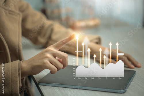 A woman is pointing at a graph on a tablet