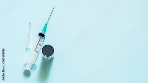 Vaccine in a bottle with a syringe on a blue background.The concept of medicine, healthcare and science. photo