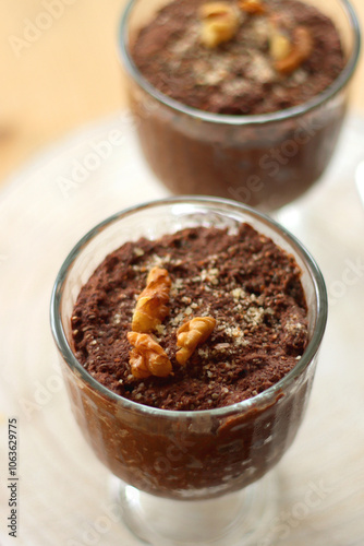 Two bowls of chia seed, chocolate and orange pudding. Healthy snack, wooden background. Selective focus.