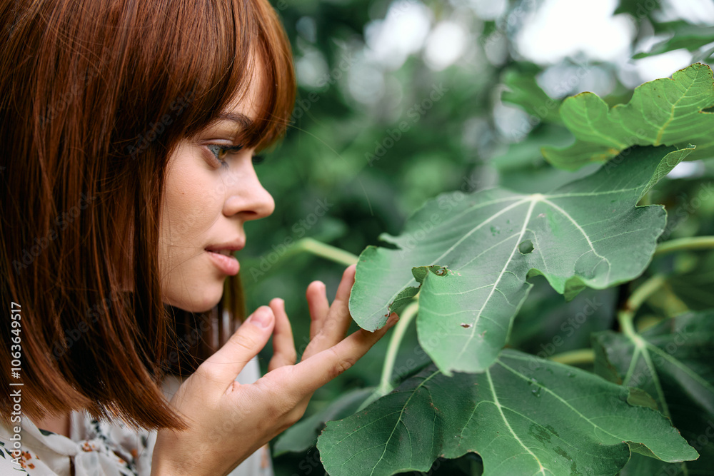 Woman enjoying the fresh aroma of plant leaves in rural garden setting Woman enjoying the fresh aroma of plant leaves in rural garden setting