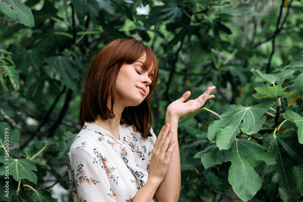 Tranquil woman connecting with nature by touching leaves on a tree in the forest Tranquil woman connecting with nature by touching leaves on a tree in the forest