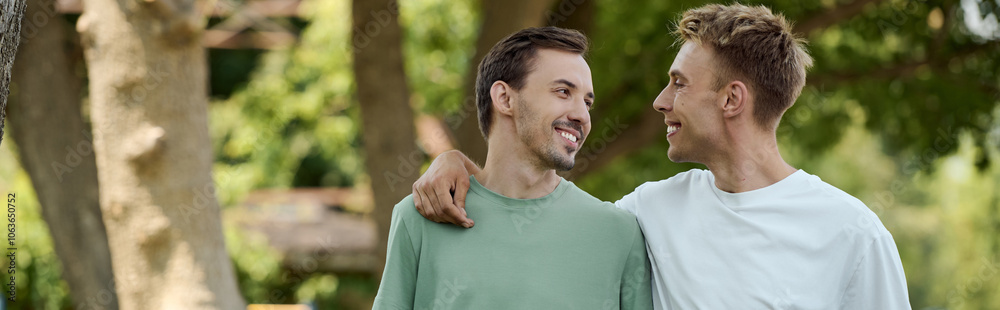 Two smiling men enjoy a sunny afternoon in a beautiful park, embracing their love for each other. Two smiling men enjoy a sunny afternoon in a beautiful park, embracing their love for each other.