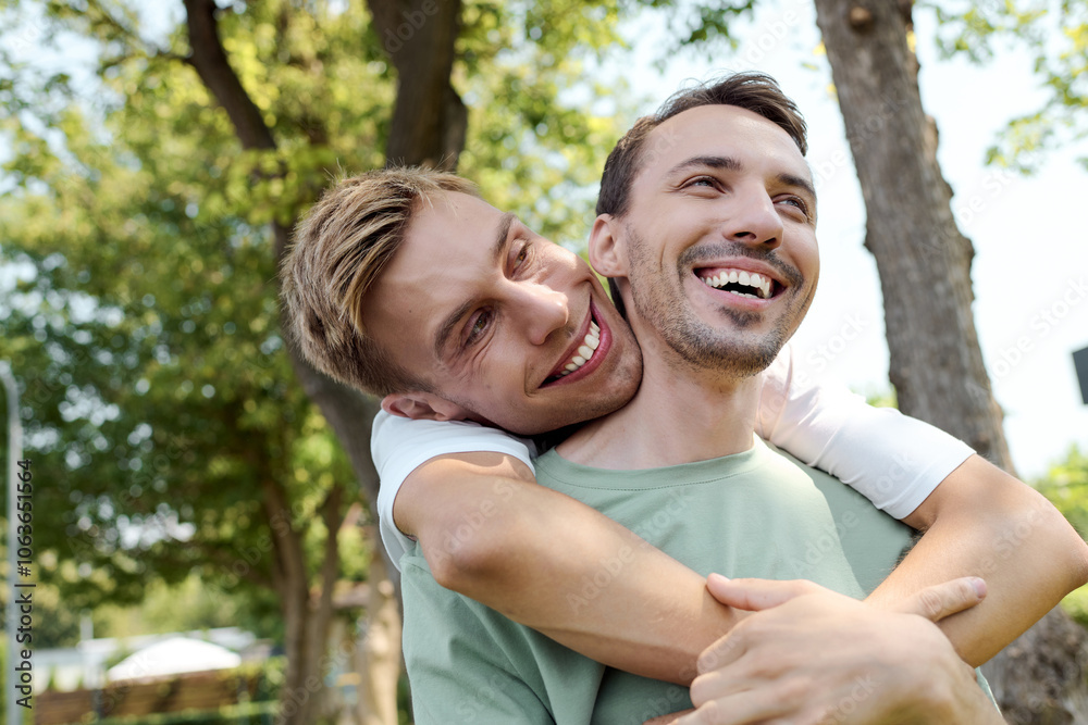 Two happy individuals embrace warmly under the bright sun among lush greenery. Two happy individuals embrace warmly under the bright sun among lush greenery.