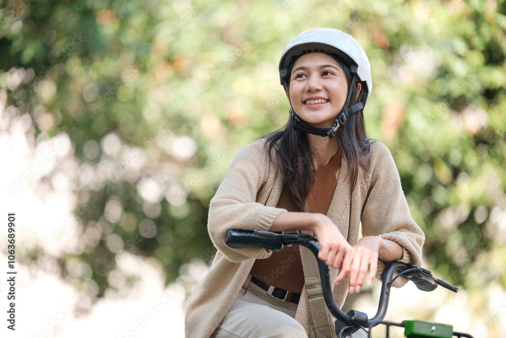 Obraz premium A woman is sitting on a bicycle wearing a helmet