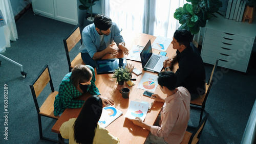 Skilled project manager walking at table while colleague brainstorm idea. Business team working together to plan marketing strategy while looking at data analysis or financial statistic. Convocation. photo