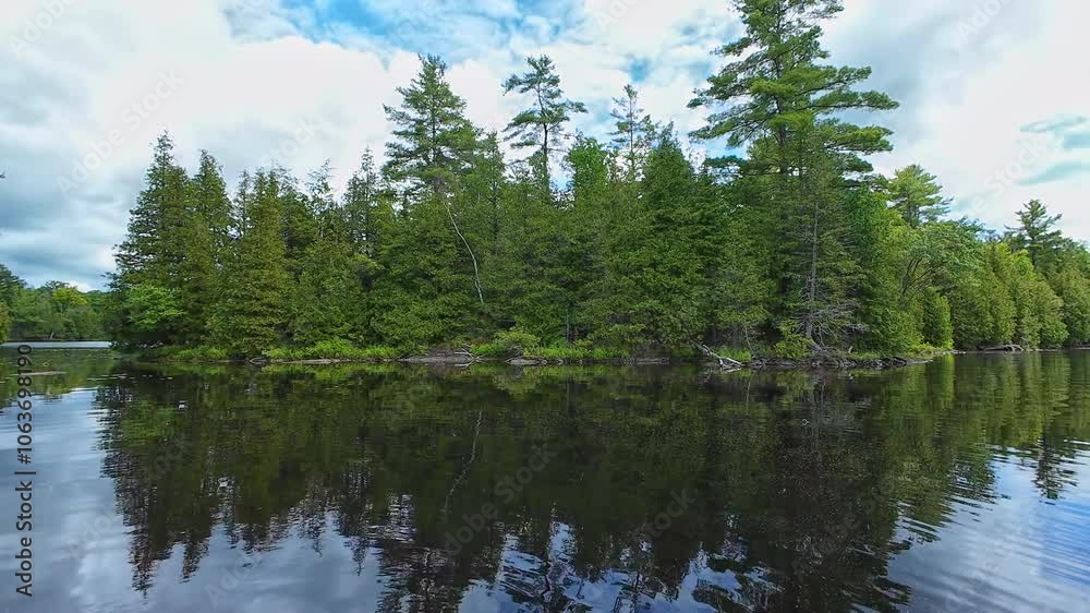 Beautiful peaceful view of summer lake. Shot at North of Ontario, Canada. Establishing shot of lake in North America. Picturesque northern lake. Calm water mirroring landscape. Beautiful peaceful view of summer lake. Shot at North of Ontario, Canada. Establishing shot of lake in North America. Picturesque northern lake. Calm water mirroring landscape.