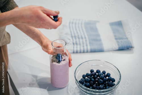 Obraz na płótnie Close up of a woman making a smoothie with fruits and berries; selective focus. Healthy food concept. w salonie