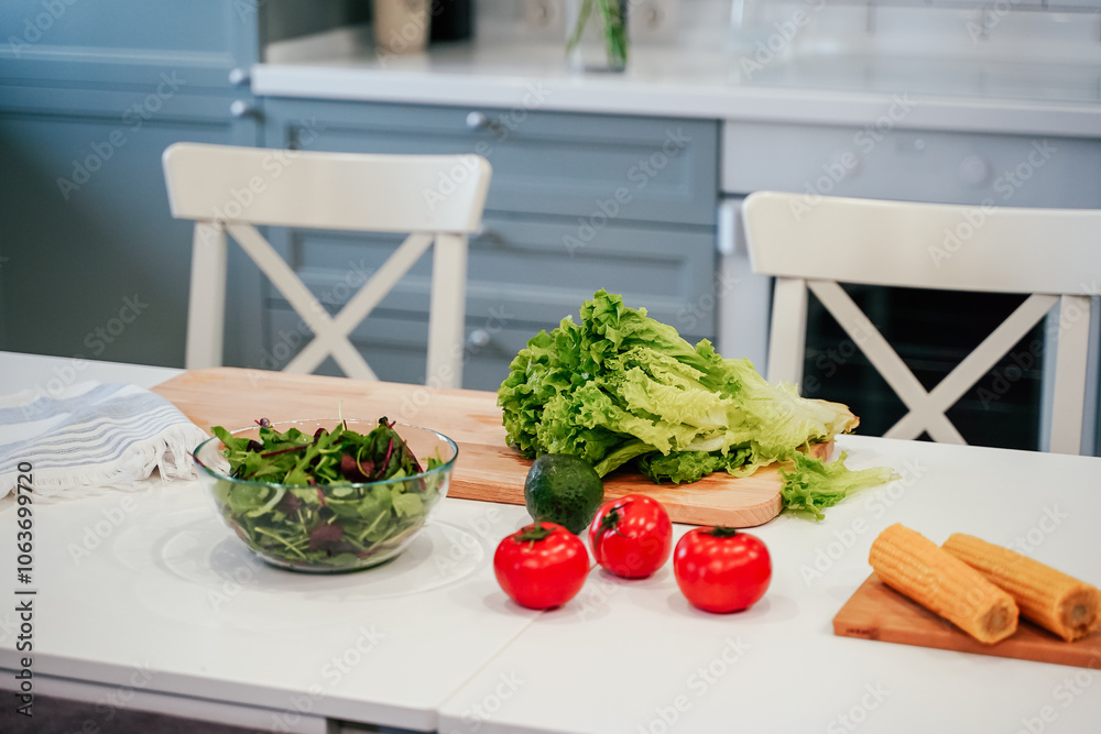 Full bowl of fresh green salad close up on a light table on a kitchen. Concept helpful and healthy food