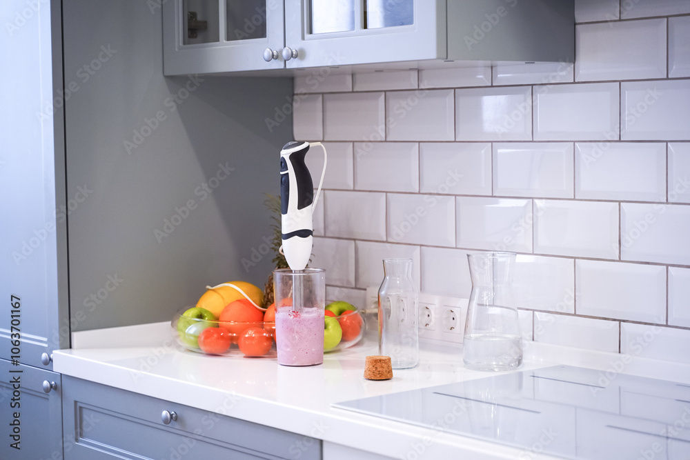 Close up of a woman making a smoothie with fruits and berries; selective focus. Healthy food concept.