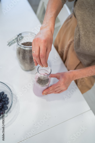 Obraz na płótnie Close up of a woman making a smoothie with fruits and berries; selective focus. Healthy food concept. w salonie