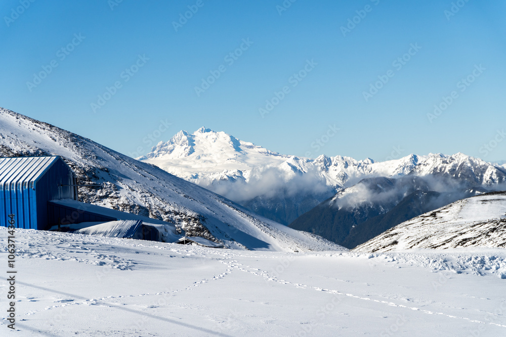 A breathtaking view of snow-covered mountains with a ski resort nestled in the Andes, highlighting the winter beauty of this iconic mountain range.